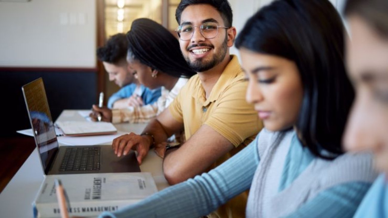 education-university-students-lecture-studying-learning-business-management-scholarship-college-portrait-happy-man-with-laptop-books-group-friends-modern-classroom