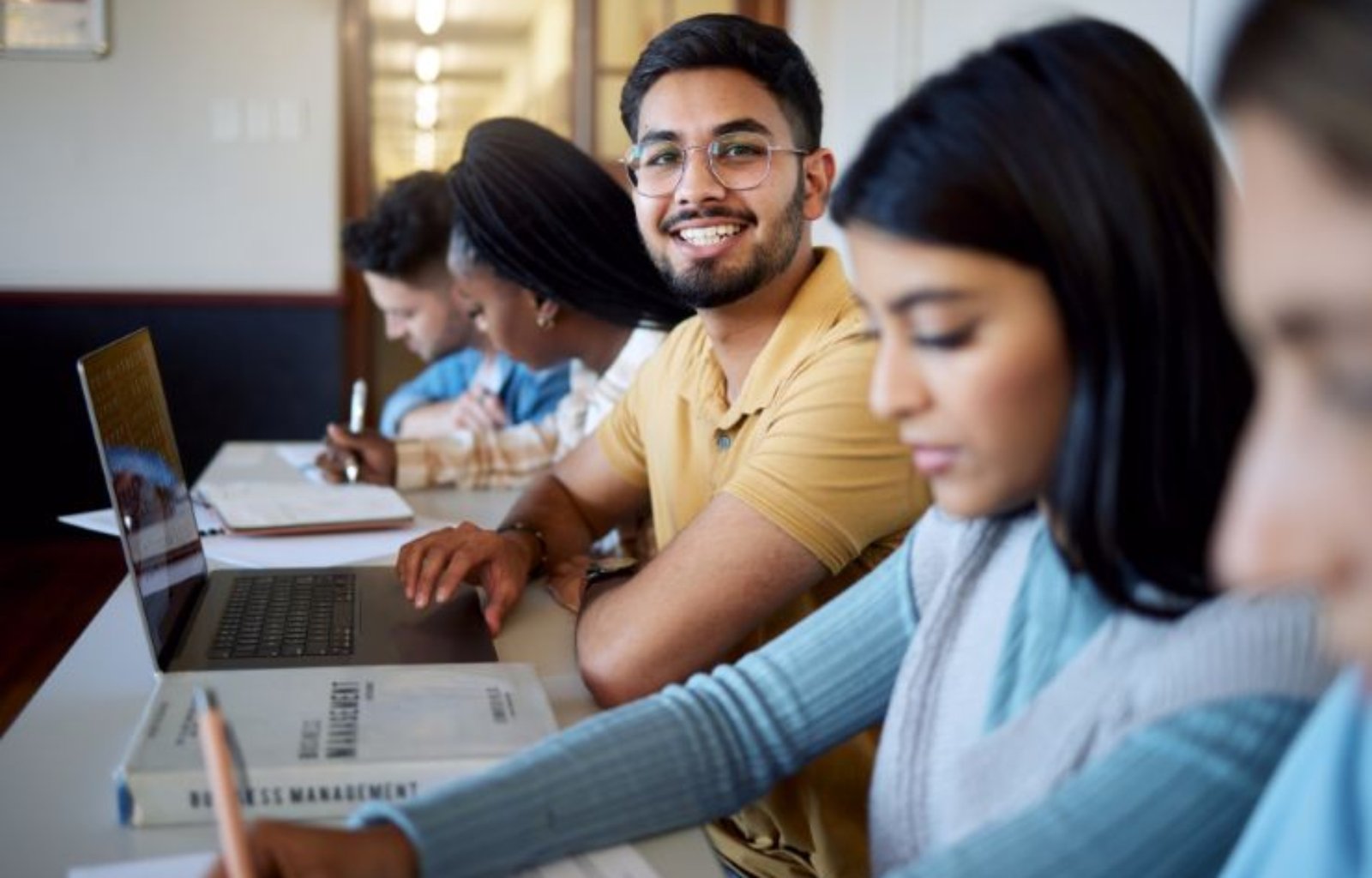 education-university-students-lecture-studying-learning-business-management-scholarship-college-portrait-happy-man-with-laptop-books-group-friends-modern-classroom